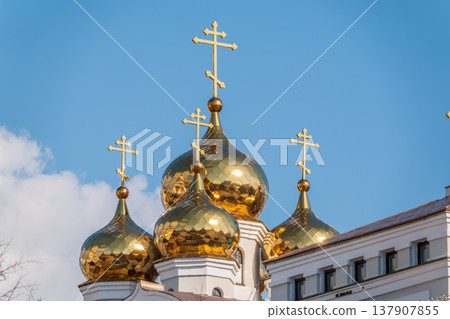 Gilded dome with a cross of an Orthodox church against a blue clear sky Gilded dome with a cross of an Orthodox church against a blue clear sky 137907855