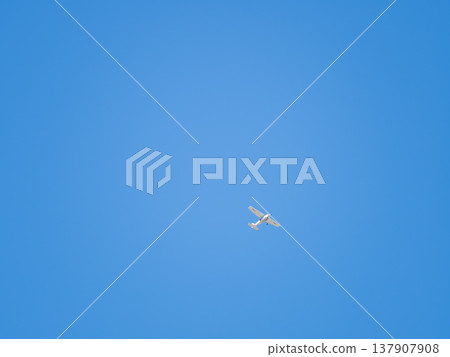 Small ultralight airplane with overhead wing and single propeller flying in sunset sky. Small ultralight airplane with overhead wing and single propeller flying in sunset sky. 137907908