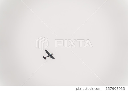 Small ultralight airplane with overhead wing and single propeller flying in sunset sky. Small ultralight airplane with overhead wing and single propeller flying in sunset sky. 137907933