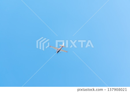 Small ultralight airplane with overhead wing and single propeller flying in sunset sky. 137908021