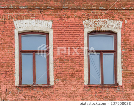 Two windows of the old mansion 19 century with brown bricks wall 137908028