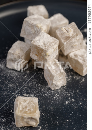soft and fresh Turkish delight sprinkled with powdered white sugar, cubic white soft pieces of Turkish delight with nuts and dried fruits inside soft and fresh Turkish delight sprinkled with powdered white sugar, cubic white soft pieces of Turkish delight with nuts and dried fruits inside 137908974