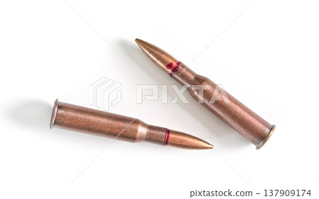 Two copper machine gun bullets isolated on white background Two copper machine gun bullets isolated on white background 137909174