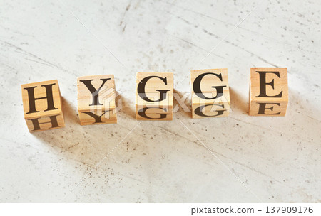 Five wooden cubes with letters HYGGE (scandinavian for word for mood of coziness) on white stone like board, view from above Five wooden cubes with letters HYGGE (scandinavian for word for mood of coziness) on white stone like board, view from above 137909176