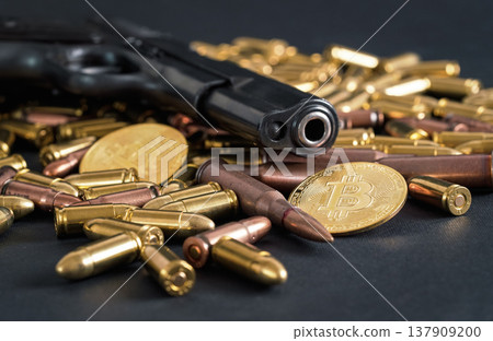 Bronze and brass gun bullets scattered on dark table, black pistol barrel, golden bitcoin coins near - illegal use of cryptocurrency to purchase weapon concept 137909200