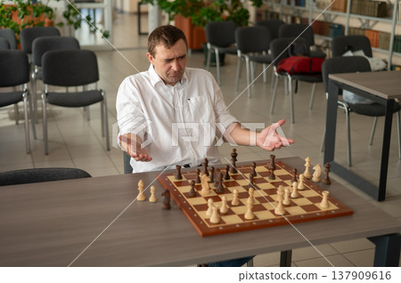 Caucasian man thinking about a chess move. Caucasian man thinking about a chess move. 137909616