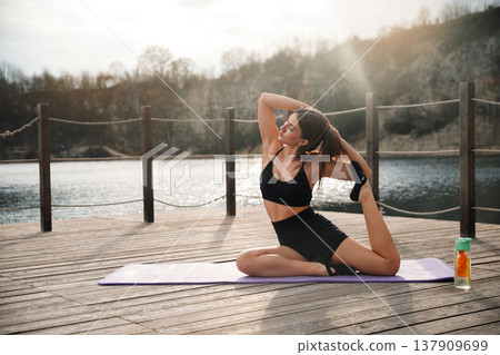 Attractive Woman Performing Deep Backbend Yoga Pose Outdoors At Lake. Fitness And Flexibility Concept Attractive Woman Performing Deep Backbend Yoga Pose Outdoors At Lake. Fitness And Flexibility Concept 137909699
