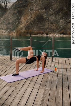 Attractive Woman Performing Advanced Yoga Pose Outdoors At Lake. Strength And Flexibility Training Concept Attractive Woman Performing Advanced Yoga Pose Outdoors At Lake. Strength And Flexibility Training Concept 137909720