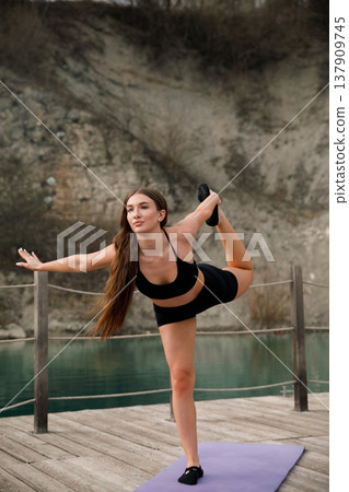 Pretty Woman Practicing Dancer Pose On Yoga Mat At Lake. Balance And Flexibility Yoga Concept Pretty Woman Practicing Dancer Pose On Yoga Mat At Lake. Balance And Flexibility Yoga Concept 137909745