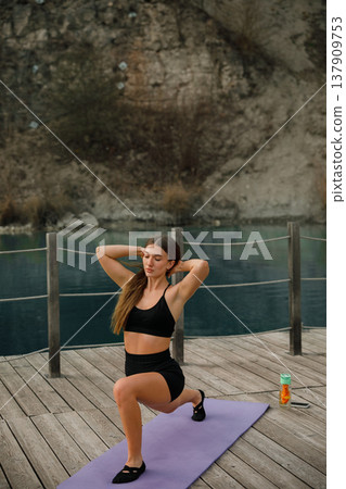 Beautiful Woman Holding Lunge Pose With Hands Together At Lake. Posture And Balance Training Concept Beautiful Woman Holding Lunge Pose With Hands Together At Lake. Posture And Balance Training Concept 137909753