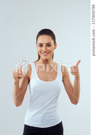 Portrait of beautiful woman on isolated studio background, hold water glass. Drink water. Diet concept Portrait of beautiful woman on isolated studio background, hold water glass. Drink water. Diet concept 137909786