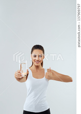 Portrait of beautiful woman on isolated studio background, hold water glass. Drink water. Diet concept 137909797