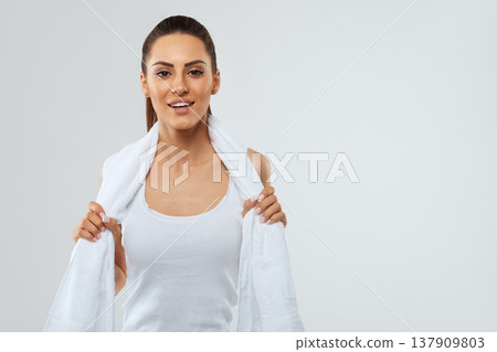 Beautiful woman with towel on her shoulders. Fitness girl model. Sport and healthy lifestyle. Beautiful woman with towel on her shoulders. Fitness girl model. Sport and healthy lifestyle. 137909803