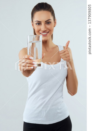 Portrait of beautiful woman on isolated studio background, hold water glass. Drink water. Diet concept 137909805