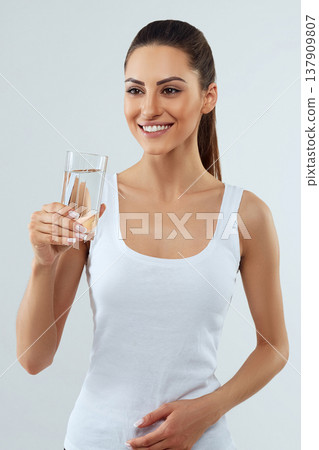 Beautiful woman holding water glass. Drink water. Girl with glass of water. Diet concept Beautiful woman holding water glass. Drink water. Girl with glass of water. Diet concept 137909807