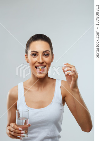 Woman Taking Vitamin Pils And Holding A Glass Of Fresh Water In Morning. Vitamin D, E, A Fish Oil Capsules,Omega-3. Diet. Nutrition. Healthy Eating 137909813