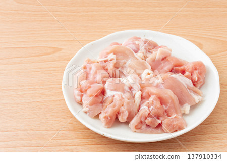 Raw chicken thigh pieces placed on a plate Raw chicken thigh pieces placed on a plate 137910334