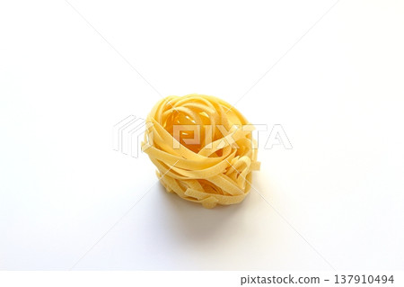 White background with dried tagliatelle pasta. 137910494