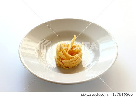 白色背景上放著乾的意大利寬麵條。 137910500