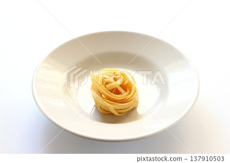White background with dried tagliatelle pasta. White background with dried tagliatelle pasta. 137910503