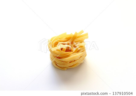 White background with dried tagliatelle pasta. White background with dried tagliatelle pasta. 137910504