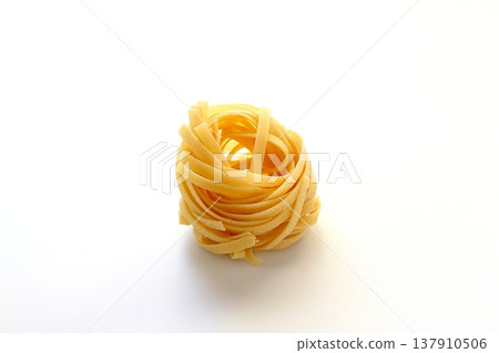 白色背景上放著乾的意大利寬麵條。 137910506