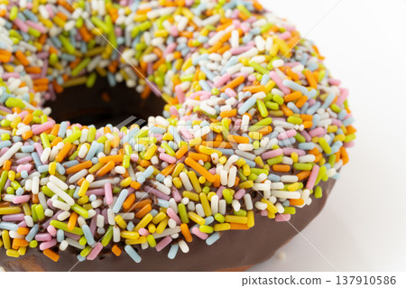 特寫鏡頭：一個撒滿彩色糖屑的巧克力甜甜圈。 137910586