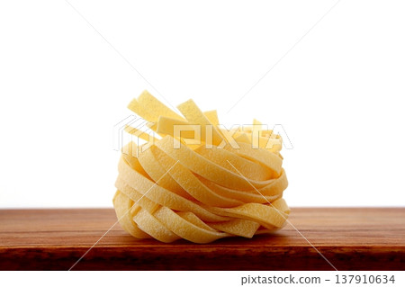 白色背景上放著乾的意大利寬麵條。 137910634