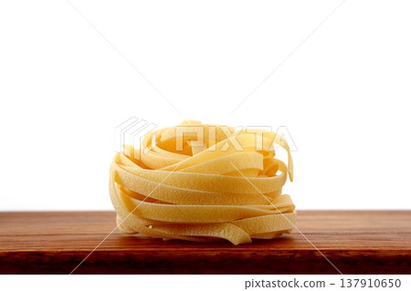 白色背景上放著乾的意大利寬麵條。 137910650