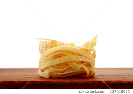 白色背景上放著乾的意大利寬麵條。 137910655