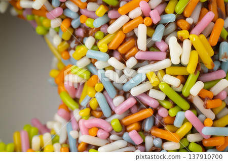 特寫：巧克力甜甜圈上撒滿了五彩繽紛的糖屑。 137910700