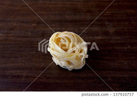 Table background: dried tagliatelle pasta Table background: dried tagliatelle pasta 137910757