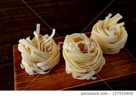 Table background: dried tagliatelle pasta 137910808