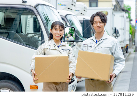 工人們在卡車前舉起紙箱 137911129