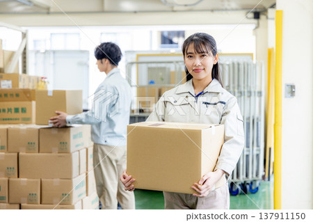 Young worker working in a warehouse Young worker working in a warehouse 137911150