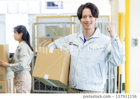 Young worker working in a warehouse Young worker working in a warehouse 137911156