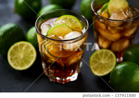 Glasses of cold Cuba Libre cocktail on dark background, selective focus. 137911880