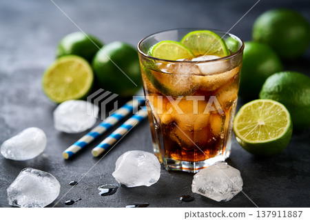 Cocktail cuba libre with brown rum, cola and lime in a glasses on a dark table. 137911887