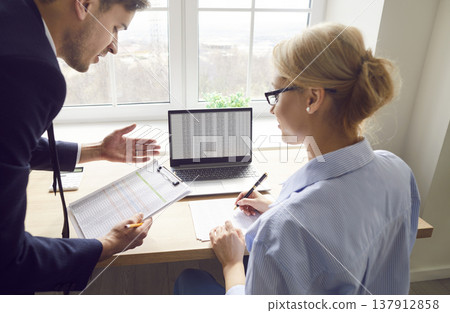 Financial experts analyze data and discuss business strategy with documents in office. Financial experts analyze data and discuss business strategy with documents in office. 137912858