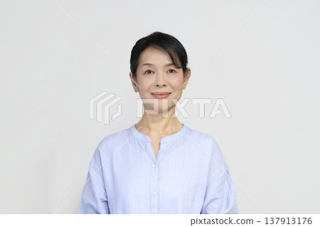 A woman in her late 50s smiling at the camera A woman in her late 50s smiling at the camera 137913176
