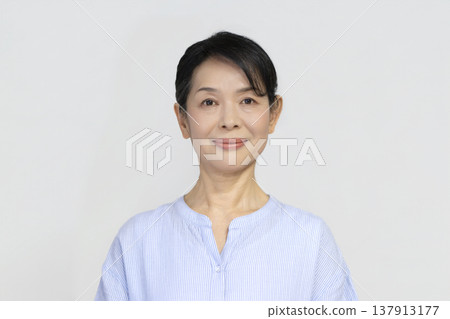 一位年近六十的女士對著鏡頭微笑 137913177