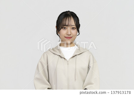 一位年輕女子麵帶微笑，看向鏡頭；白色背景的肖像照。 137913178