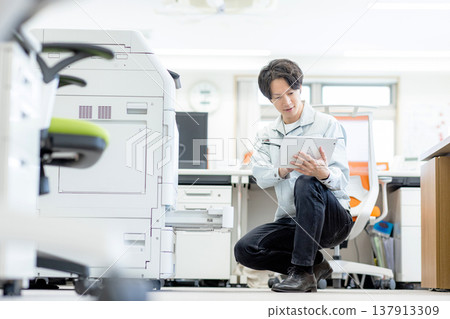 A man inspecting a copier 137913309