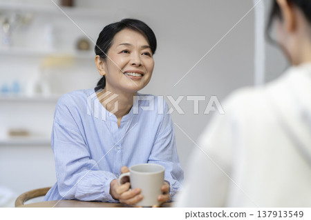 一位年近六十的女士微笑地與人交談。 137913549