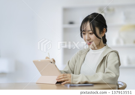 Female student studying with a tablet Female student studying with a tablet 137913551