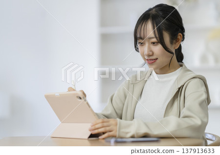 用平板電腦學習的女學生 用平板電腦學習的女學生 137913633
