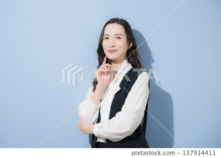 A stylish long vest (gilet) in business casual attire, with a cool, long black hairstyle and arms crossed. A stylish long vest (gilet) in business casual attire, with a cool, long black hairstyle and arms crossed. 137914411