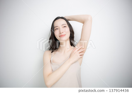 一位年輕女子在白色背景下接受上半身(如腋下和手臂)美容護理和美學服務的圖片。 一位年輕女子在白色背景下接受上半身(如腋下和手臂)美容護理和美學服務的圖片。 137914436