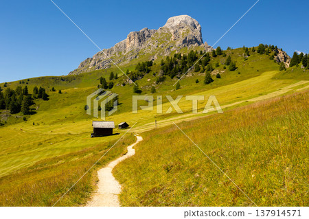 View of Peitlerkofel with wooden houses, green trees and grand mountain View of Peitlerkofel with wooden houses, green trees and grand mountain 137914571