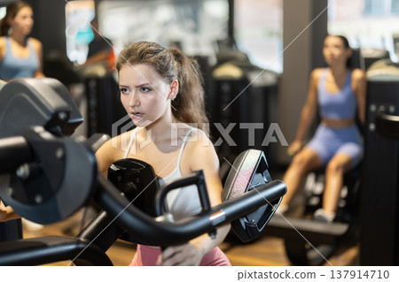 Young woman doing exercises for shoulders Young woman doing exercises for shoulders 137914710